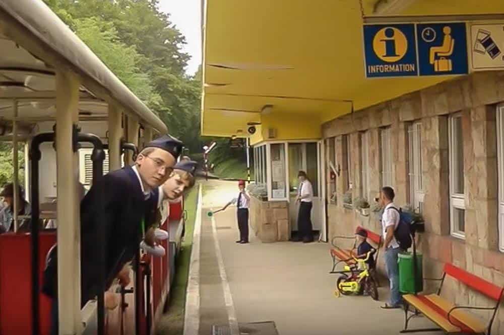 children train conductors looking through the windows of the children's train in Budapest children workers on the train are an interesting thing about Budapest