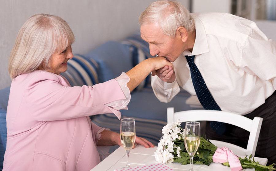 Man kissing a woman's hand as they meet